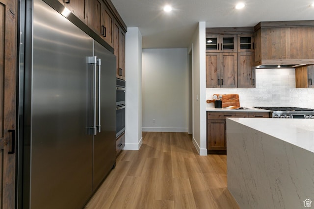 1792 N Siena Cir Unit 13, Pleasant Grove, UT 84062 - kitchen featuring appliances with stainless steel finishes, light wood-style floors, backsplash, baseboards, and glass insert cabinets