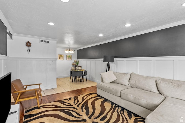 66 W Lester Ave Unit K27, Murray, UT 84107 - living room featuring wainscoting, crown molding, wood finished floors, a chandelier, and a decorative wall
