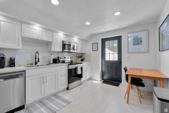 1677 N 2640 W, Lehi, UT 84043 - kitchen featuring appliances with stainless steel finishes, a sink, baseboards, white cabinets, and light countertops