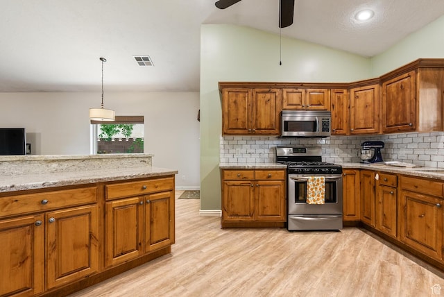 114 E Canterwood Dr, Washington, UT 84780 - kitchen with stainless steel appliances, brown cabinetry, lofted ceiling, light wood-style floors, and tasteful backsplash