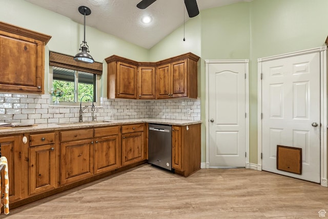 114 E Canterwood Dr, Washington, UT 84780 - kitchen featuring dishwasher, a sink, lofted ceiling, brown cabinets, and decorative backsplash