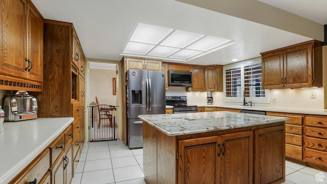 4755 S Banbury, Ogden, UT 84403 - kitchen with stainless steel appliances, light tile patterned floors, a kitchen island, brown cabinets, and light stone counters