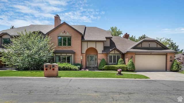 4755 S Banbury, Ogden, UT 84403 - tudor house featuring a chimney, an attached garage, a front lawn, and concrete driveway