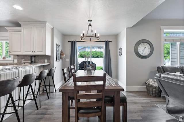 580 N Cherry Ridge Ln, Richmond, UT 84333 - dining space with a chandelier, healthy amount of natural light, baseboards, dark wood-style flooring, and a textured ceiling