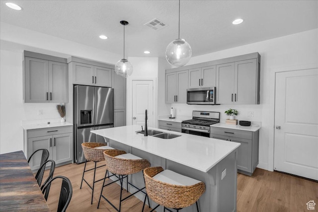 2667 E Wake Ln, St George, UT 84790 - kitchen featuring stainless steel appliances, gray cabinetry, a sink, a breakfast bar, and recessed lighting