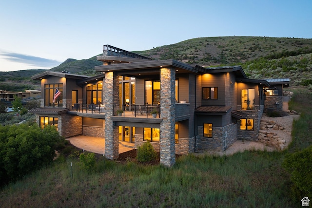 1703 N Chimney Rock Rd Unit 532, Heber City, UT 84032 - back of house with stone siding, a balcony, a standing seam roof, and a mountain view