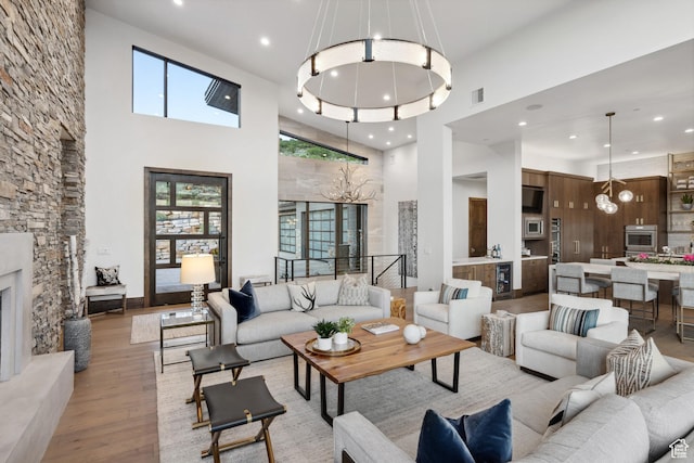 1703 N Chimney Rock Rd Unit 532, Heber City, UT 84032 - living area with a chandelier, a towering ceiling, light wood-type flooring, recessed lighting, and wine cooler