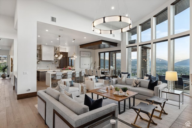 1703 N Chimney Rock Rd Unit 532, Heber City, UT 84032 - living room with healthy amount of natural light, a mountain view, light wood-type flooring, a towering ceiling, and a chandelier