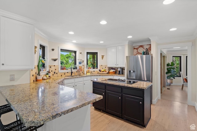 2692 S Grand Oak Cir E, Bountiful, UT 84010 - kitchen with cooktop, stainless steel refrigerator with ice dispenser, a sink, white cabinets, and recessed lighting