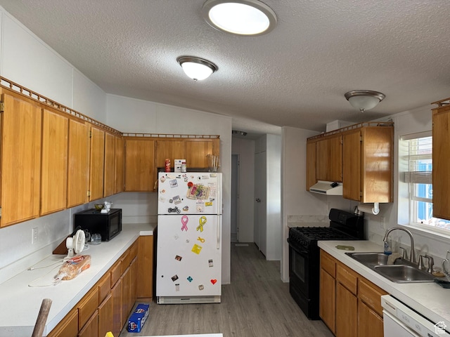 6153 E 2000 N, Roosevelt, UT 84066 - kitchen featuring black appliances, a sink, a textured ceiling, brown cabinets, and under cabinet range hood
