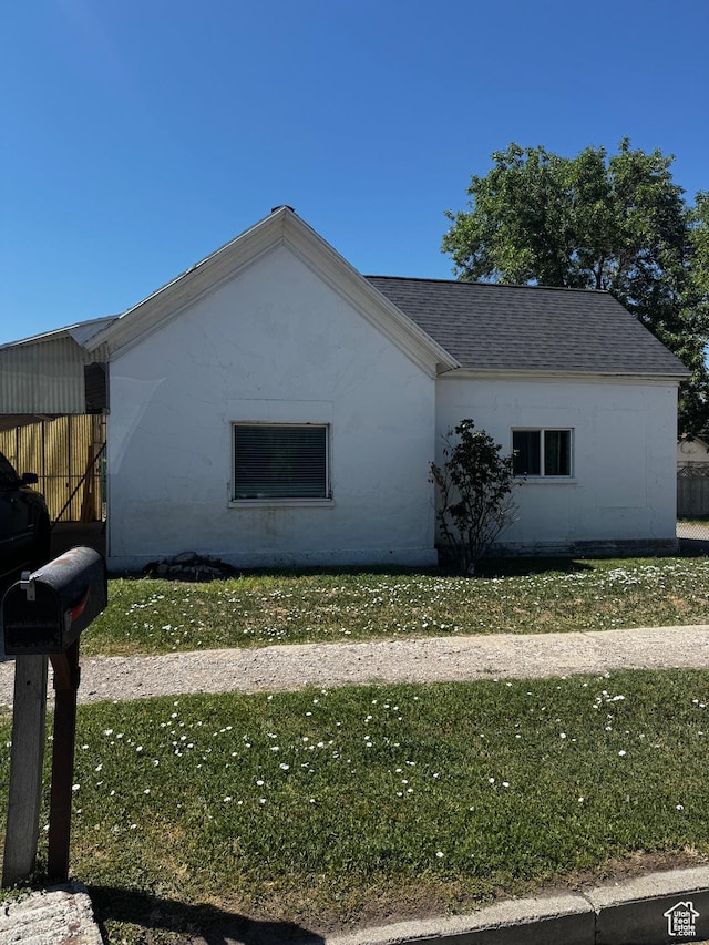 188 E 100 N, Nephi, UT 84648 - view of side of home with roof with shingles, a yard, and concrete block siding