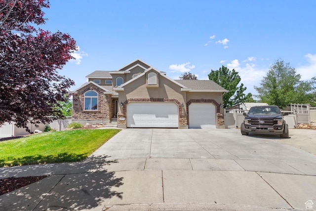 8002 S Overton Dr, West Jordan, UT 84081 - view of front facade with stucco siding, concrete driveway, stone siding, and a garage