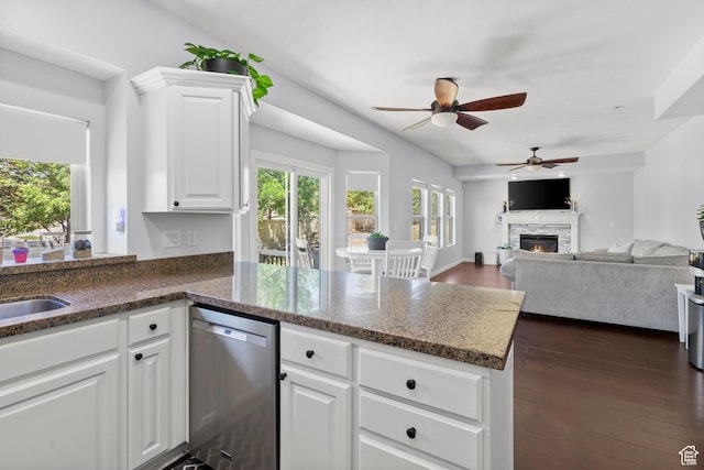 8002 S Overton Dr, West Jordan, UT 84081 - kitchen with dishwasher, a peninsula, ceiling fan, a fireplace, and dark stone countertops