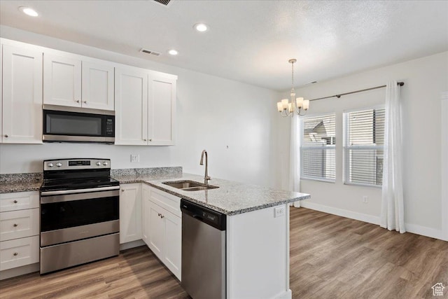 290 N 100 W, Morgan, UT 84050 - kitchen featuring stainless steel appliances, a sink, a peninsula, white cabinetry, and recessed lighting