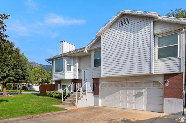 1022 E Lafayette St S, Sandy, UT 84094 - split foyer home featuring brick siding, an attached garage, a chimney, concrete driveway, and a front lawn