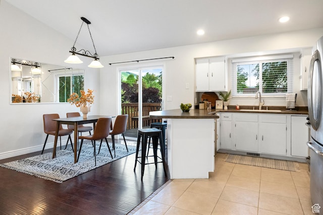 1022 E Lafayette St S, Sandy, UT 84094 - kitchen with a sink, dark countertops, healthy amount of natural light, white cabinets, and vaulted ceiling