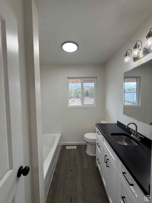 1698 Kenilworth Rd, Helper, UT 84526 - bathroom featuring vanity, toilet, a bath, wood finished floors, and baseboards