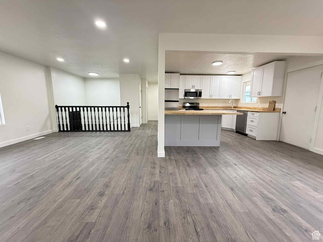 1698 Kenilworth Rd, Helper, UT 84526 - kitchen featuring stainless steel appliances, open floor plan, wood finished floors, white cabinetry, and recessed lighting