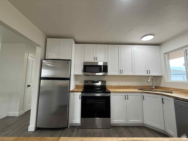 1698 Kenilworth Rd, Helper, UT 84526 - kitchen featuring stainless steel appliances, a sink, light wood-style flooring, white cabinetry, and butcher block counters