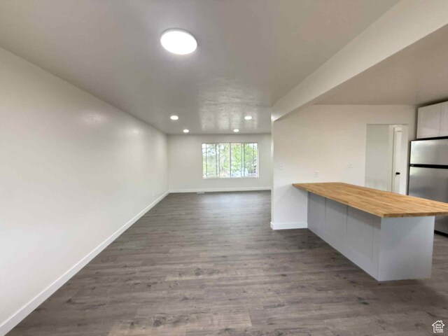1698 Kenilworth Rd, Helper, UT 84526 - unfurnished living room featuring baseboards, recessed lighting, and dark wood finished floors