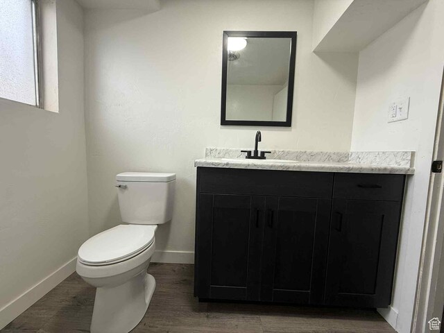1698 Kenilworth Rd, Helper, UT 84526 - bathroom featuring vanity, toilet, baseboards, and wood finished floors