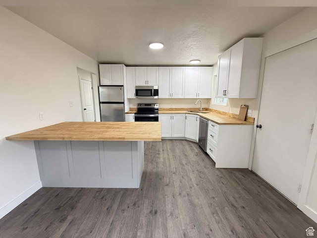 1698 Kenilworth Rd, Helper, UT 84526 - kitchen with stainless steel appliances, a peninsula, dark wood finished floors, white cabinetry, and recessed lighting