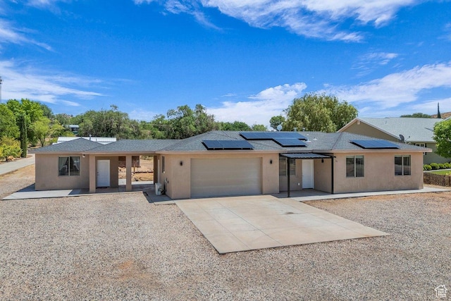 40 W Pecan Ln, Leeds, UT 84746 - single story home featuring a garage, concrete driveway, stucco siding, roof mounted solar panels, and a porch