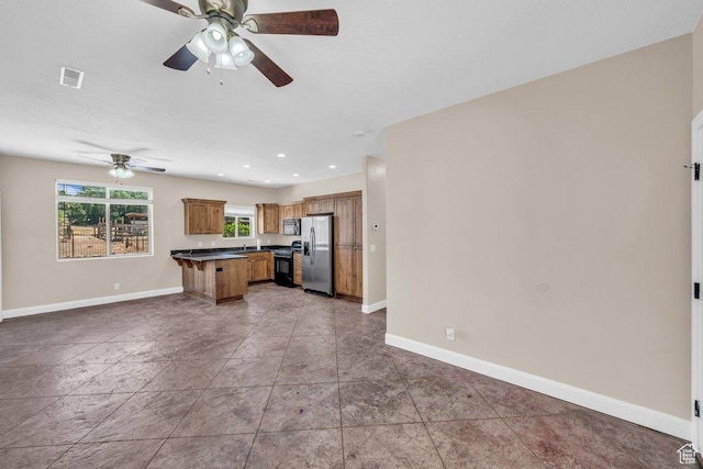 40 W Pecan Ln, Leeds, UT 84746 - kitchen with stainless steel fridge, gas range, open floor plan, dark countertops, and baseboards