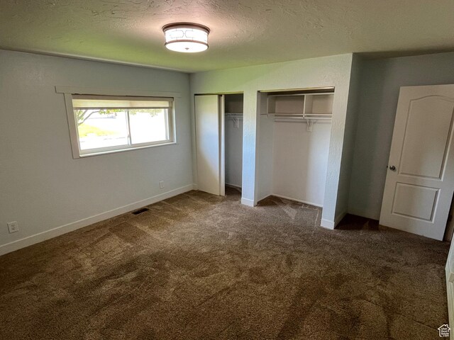 552 W 1200 N, Lehi, UT 84043 - unfurnished bedroom featuring multiple closets, carpet flooring, a textured ceiling, and baseboards