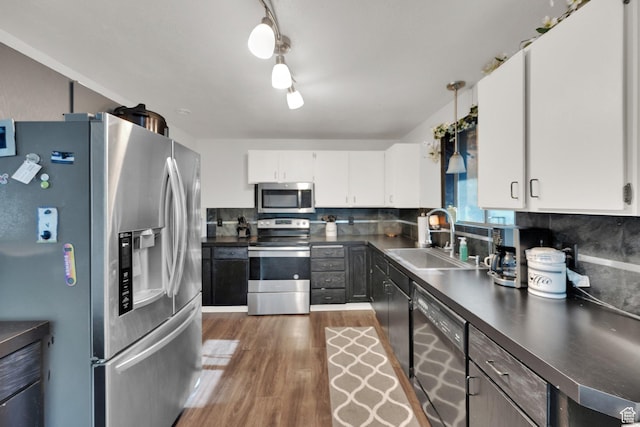 1657 N 1500 W, Clinton, UT 84015 - kitchen with appliances with stainless steel finishes, a sink, dark countertops, wood finished floors, and decorative backsplash