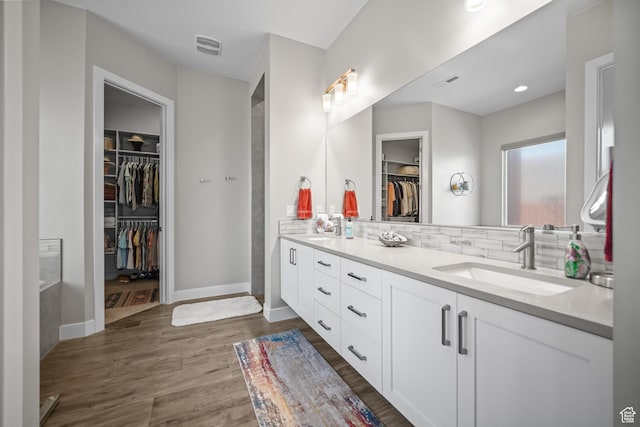 97 S 495 W, Ivins, UT 84738 - bathroom with double vanity, a walk in closet, wood finished floors, backsplash, and baseboards