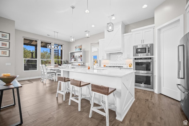 97 S 495 W, Ivins, UT 84738 - kitchen featuring appliances with stainless steel finishes, a sink, light countertops, a breakfast bar, and decorative backsplash