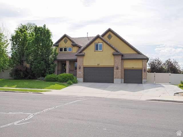 12687 S Verona Creek Way W, Riverton, UT 84065 - traditional-style house featuring driveway, stucco siding, a gate, an attached garage, and a tile roof