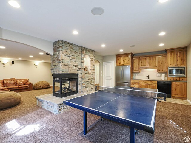 12687 S Verona Creek Way W, Riverton, UT 84065 - game room with arched walkways, light carpet, a sink, recessed lighting, and a stone fireplace