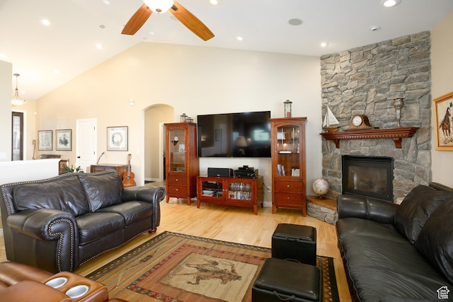 2073 S Allen Rd, Taylor, UT 84401 - living room featuring a ceiling fan, arched walkways, light wood-style flooring, a stone fireplace, and high vaulted ceiling