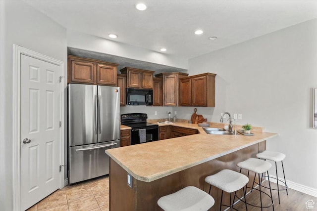 1853 W 2300 S, Woods Cross, UT 84087 - kitchen with black appliances, a sink, a peninsula, light countertops, and a breakfast bar area