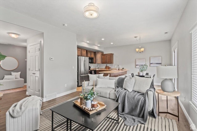 1853 W 2300 S, Woods Cross, UT 84087 - living room with wood finished floors, baseboards, a chandelier, and recessed lighting