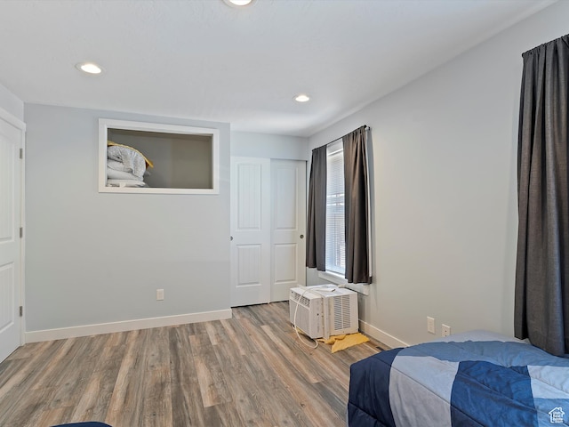 1631 E 1470 S Unit 5E, Ogden, UT 84404 - bedroom featuring wood finished floors, recessed lighting, baseboards, and an AC wall unit