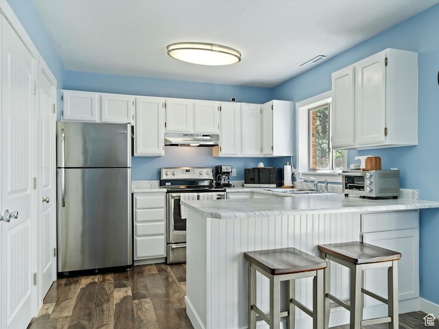 1631 E 1470 S Unit 5E, Ogden, UT 84404 - kitchen featuring stainless steel appliances, under cabinet range hood, dark wood-type flooring, a peninsula, and white cabinets