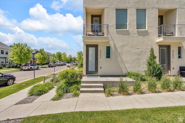 6202 W Birch Run Rd, South Jordan, UT 84009 - property entrance featuring a balcony and stucco siding