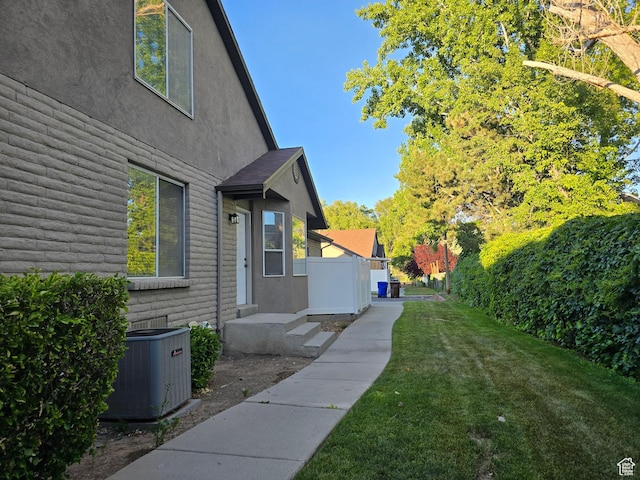 82 S Santa Rita Pl, West Jordan, UT 84088 - view of home's exterior featuring central air condition unit, stucco siding, and a lawn