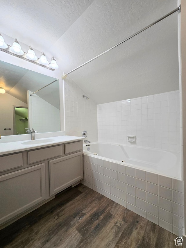 82 S Santa Rita Pl, West Jordan, UT 84088 - bathroom featuring vaulted ceiling, vanity, wood finished floors, and tiled shower / bath