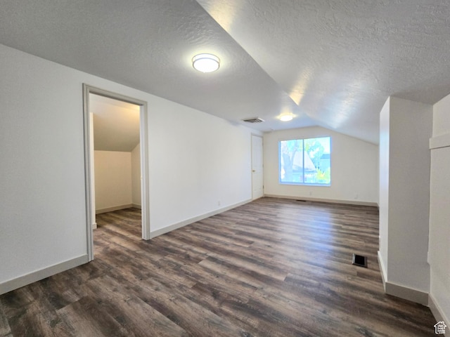 82 S Santa Rita Pl, West Jordan, UT 84088 - bonus room with vaulted ceiling, dark wood-style flooring, baseboards, and a textured ceiling