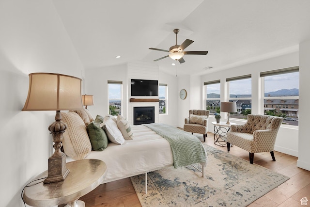 10777 S Lamond Dr W, South Jordan, UT 84009 - bedroom with light wood-style floors, lofted ceiling, a fireplace, and ceiling fan