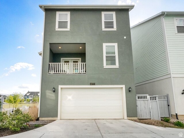 10777 S Lamond Dr W, South Jordan, UT 84009 - view of front of property with stucco siding, a garage, driveway, and a balcony