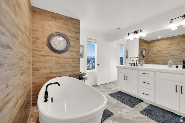 10777 S Lamond Dr W, South Jordan, UT 84009 - bathroom featuring double vanity, a freestanding tub, and wooden walls
