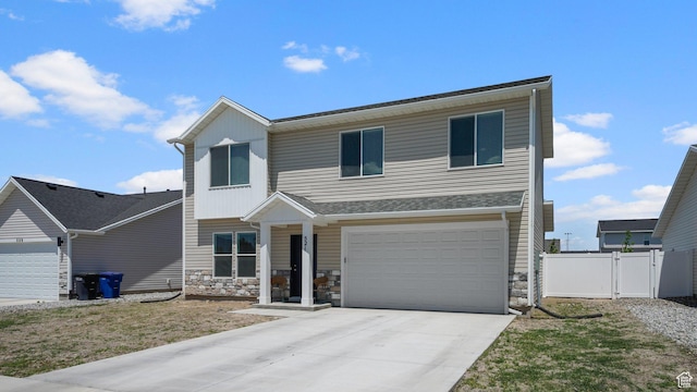 521 W 1110 N Unit Hc4, Logan, UT 84341 - view of front of property with concrete driveway, stone siding, a garage, and a gate