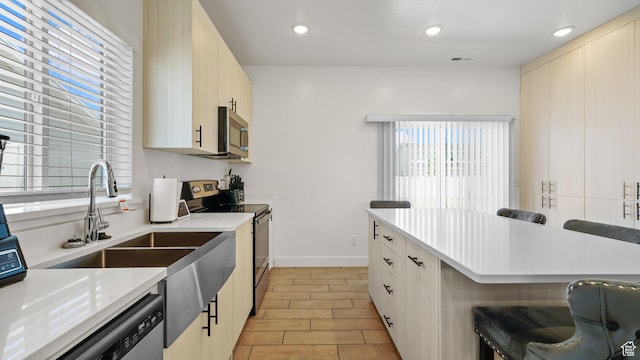 521 W 1110 N Unit Hc4, Logan, UT 84341 - kitchen with appliances with stainless steel finishes, light countertops, a breakfast bar, recessed lighting, and baseboards