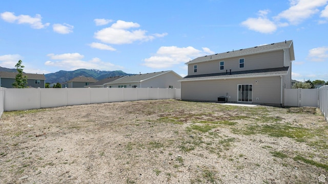 521 W 1110 N Unit Hc4, Logan, UT 84341 - rear view of house featuring a mountain view, a fenced backyard, central AC unit, and a patio