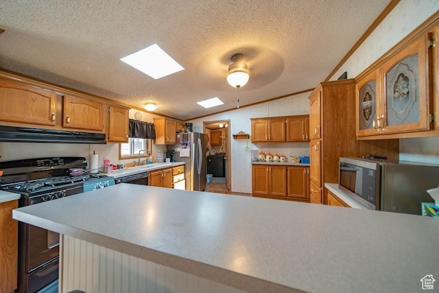 1700 W 2250 N, Helper, UT 84526 - kitchen with under cabinet range hood, lofted ceiling, black appliances, a textured ceiling, and brown cabinetry